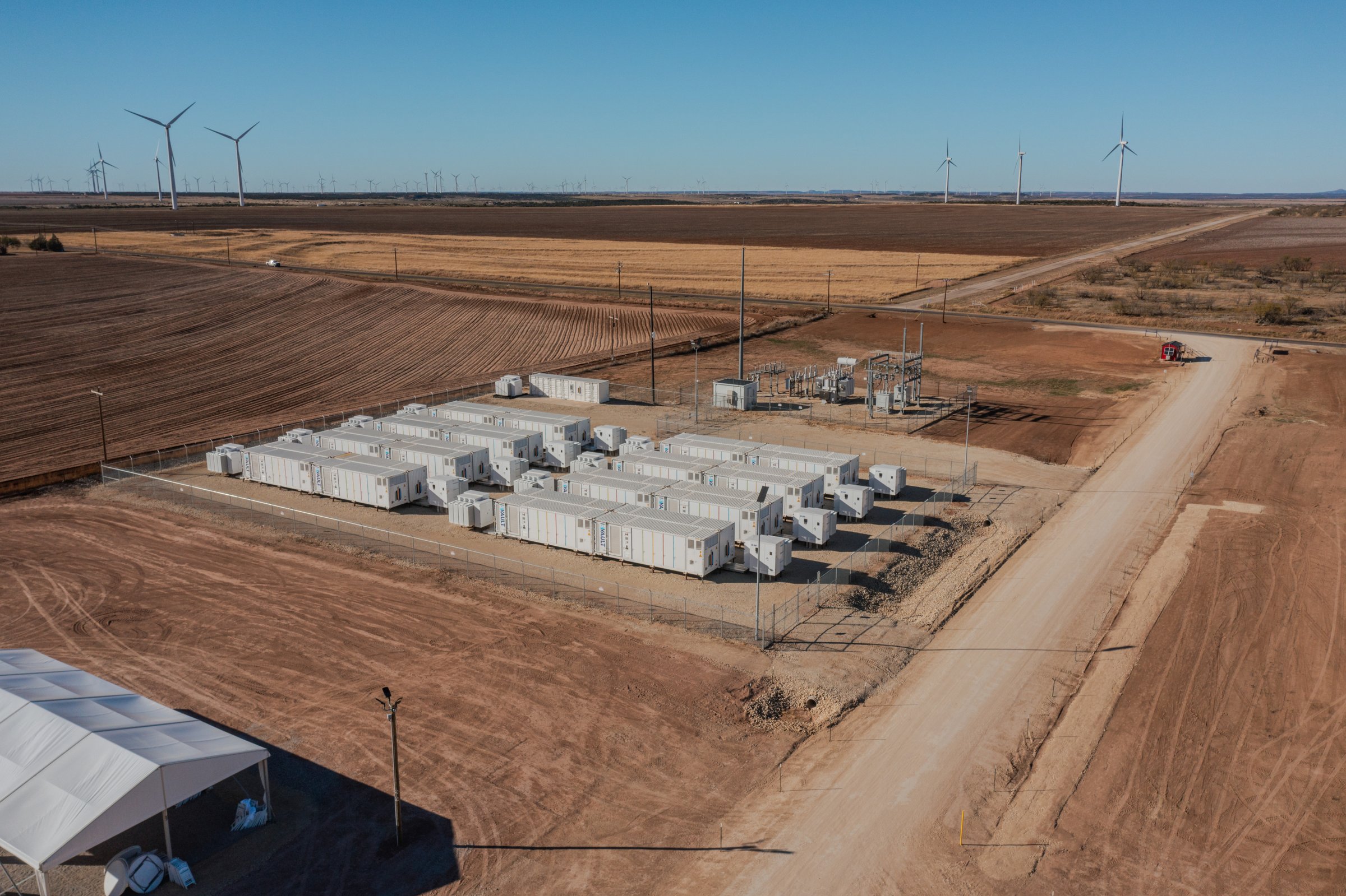 Aerial view of an Energy Vault storage array beside wind turbines