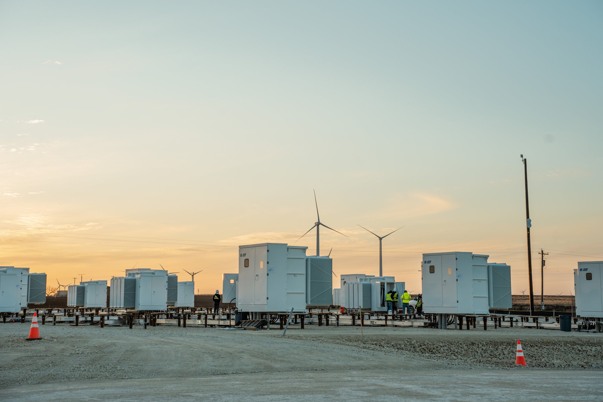 Energy Vault storage units and wind turbines at dusk